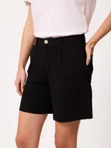 Short negro de gabardina con pinzas delanteras, bolsillos laterales y cierre frontal con botón metálico.