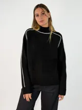 Sweater de punto negro con cuello alto y detalles de costuras en color gris claro que recorren los hombros y las mangas. Presenta un diseño de corte holgado con puños y ruedo acanalados.