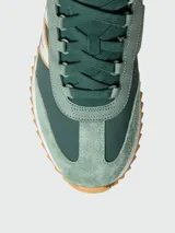 Zapatillas Moncler modelo Pacey2, confeccionadas en ante y nobuk en tonos verde militar, con detalles en blanco y marrón, cordones verde oscuro y suela dentada de goma.