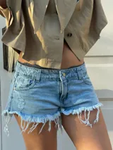 Short de jean de tiro medio, color celeste con efecto lavado, diseño corto de corte ajustado y ruedos deshilachados con flecos pronunciados. Cuenta con bolsillos clásicos y detalles de roturas sutiles en el frente.