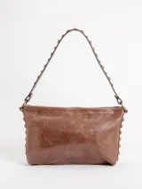 Bandolera 100% cuero color marrón, con diseño amplio y espacioso, detalles de tachas metálicas en los laterales del cuerpo y en el asa corta. Cuenta con forro interior y bolsillo con cierre.