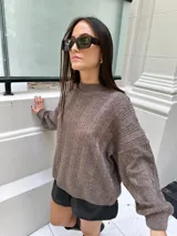 Sweater marrón tejido con diseño de ochos y cuello alto.