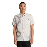 Camisa de manga corta color crema con estampado de soles en color gris. Tiene cuello clásico, cierre con botones y un bolsillo en el pecho.