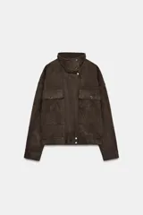 Bomber de corte oversize confeccionada en tejido efecto ante color marrón. Presenta cuello subido, cierre frontal con cremallera y botones ocultos por solapa, y bolsillos delanteros con solapa y botón.
