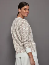 Cárdigan tejido intarsia color crema con diseño de raquetas de tenis en patrón de damero. Escote en V con botones en el frente, ribete de punto acanalado y bolsillos frontales.