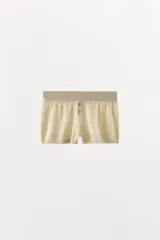 Mini shorts de punto de algodón color beige, de tiro medio con cintura elástica y detalle de botones frontales.