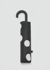 Paraguas plegable de color negro con estampado de lunares blancos grandes, cuenta con mango curvo ergonómico.