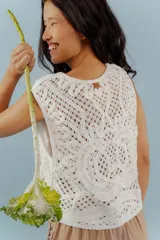 Chaleco negro de tejido de punto abierto, sin mangas y sin cierre, con cuello solapa.