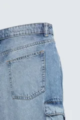 Bermuda de denim de algodón, color celeste lavado, de corte relajado (relaxed fit). Presenta cinco bolsillos, incluyendo bolsillos cargo plastrón con solapa en las perneras.