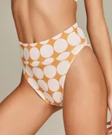 Bikini de dos piezas con estampado de lunares grandes en color naranja quemado y blanco. El corpiño es de escote profundo en V con tirantes anchos. La bombacha es de tiro alto.