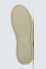 Zapatilla deportiva de estilo retro con diseño de paneles en combinación de colores crema, verde azulado y detalle en rojo en el talón. Presenta suela con volumen y cierre con cordones.