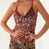 Blusa negra con lentejuelas y cuentas doradas, con tirantes finos y escote en V.