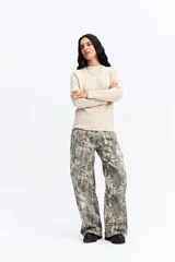 Buzo de punto negro con cuello redondo, manga larga y textura sutil. Presenta un diseño minimalista y versátil, ideal para combinar en diversas ocasiones.