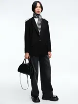 Blazer negro de corte estructurado con hombreras decoradas con apliques de perlas. Presenta cierre frontal con un botón, solapas clásicas y bolsillos laterales con solapa.