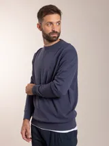 Sweater azul de tejido de punto con cuello redondo y logo bordado en el pecho.