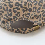 Gorra de béisbol con estampado de leopardo en tonos marrón y negro, confeccionada en tela de algodón.
