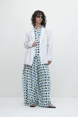 Pantalón de corte ancho con estampa geométrica de cuadrados azules, verdes y blancos.