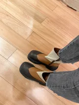 Botas de cuero color marrón y beige con caña media, cierre lateral y suela track.