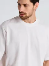 Camiseta de corte oversize color blanco, con cuello redondo y mangas cortas amplias.