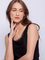 Musculosa blanca de algodón con puntilla en escote y sisas, y pequeños calados verticales en el frente.