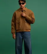 Campera bomber marrón de sarga de algodón, con cuello inglés, cierre frontal con cremallera, bolsillos cargo con botón y puños y cintura ajustados.