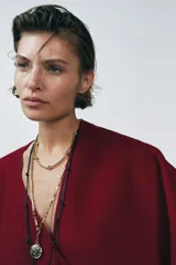 Gargantilla de metal dorado compuesta por una cadena de eslabones tubulares alternados con esferas lisas, con cierre de mosquetón ajustable.