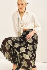 Falda larga de tiro alto con calce amplio, confeccionada en viscosa jacquard con detalles de lurex dorado. Presenta cintura elastizada con cordón de ajuste y volados irregulares en el ruedo. Incluye forrería a tono.