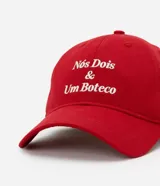 Gorra roja de sarga con visera curva, hebilla ajustable en la parte trasera y bordado frontal con la frase "Nosotros Dos y Un Boteco".