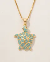Collar de bronce dorado con cadena finita y dije en forma de tortuga con incrustaciones de piedras turquesas.