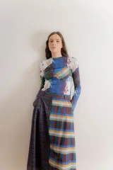 Falda midi de corte recto confeccionada en popelina de algodón, con diseño estampado floral en tonos azules y rojizos sobre fondo azul oscuro. Presenta un diseño con pinzas en la cintura y cierre frontal.