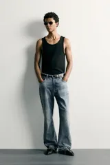 Jeans flare fit de hombre confeccionados en denim de algodón color azul con efecto lavado y roturas. Presentan diseño de cinco bolsillos, efecto salpicaduras de pintura en toda la prenda y bajo con acabado irregular.
