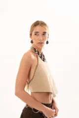 Top de gamuza color visón con escote halter y costuras decorativas con detalle de tientos de cuero en los bordes laterales.