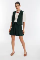 Chaleco verde oscuro de gamuza con terminaciones en cuero.