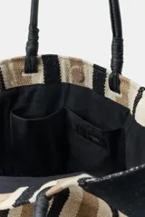 Bolso tipo shopper de algodón con diseño de rayas en tonos negro, blanco y beige. Cuenta con asas de mano de piel negra, forro interior con bolsillo y cierre magnético.