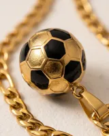 Collar de acero con baño de oro, compuesto por una cadena de eslabones y un dije en forma de pelota de fútbol esmaltada en negro.