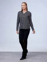 Camisa Alex & Jordan de manga larga, color negro con estampado geométrico blanco. Presenta cuello con solapa, escote en V y cierre frontal con botones.