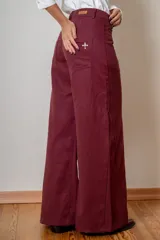 Pantalon de corte wide leg en color bordó, con cintura alta, cierre frontal con botón y bolsillos laterales.