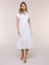 Vestido midi blanco estilo camisero de la marca Julia Jordan, confeccionado en tejido broderie 100% algodón. Presenta cuello camisero tradicional, cierre frontal con botones, mangas cortas con vuelta y cintura entallada con pinzas que da paso a una falda evasé. Cuenta con forro interior.
