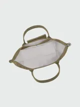 Bolso tote Longchamp modelo Le Pliage Green L, color marrón chocolate, confeccionado en lona de nylon reciclado con detalles en cuero ruso color marrón oscuro. Cuenta con cierre de cremallera y botón a presión, asas cortas para llevar al hombro y es plegable para facilitar su almacenamiento.