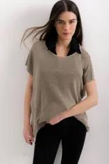 Blusa de tejido de punto fino con acabado metalizado, de corte holgado y manga corta. Presenta un escote redondo amplio que permite lucir prendas interiores.