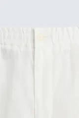 Pantalón de corte relajado confeccionado en tejido de lino. Presenta cintura elástica, bolsillos frontales, bolsillo trasero de vivo y cierre frontal con cremallera y botón.