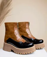 Botas cortas de cuero color marrón y negro con cierre frontal y suela track.