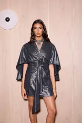 Vestido corto tipo kimono color gris metalizado, con mangas abiertas y amplias, escote en V y tiras ajustables para atar en la cintura.