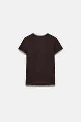 Camiseta de manga corta color marrón oscuro con textura acanalada, cuello redondo y bajo recto. Presenta un bajo superpuesto de tul o tela más clara, visible en el ruedo y en el cuello.