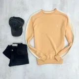 Buzo deportivo color naranja con mangas ranglan color crema y logo bordado en el pecho. Confeccionado en algodón.