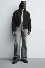 Zapato náutico de cordones, color negro, fabricado en piel con pespuntes a contraste en color claro. Presenta una horma redonda y suela track gruesa.