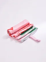 Pareo de tela, color rosa pálido, con estampado gráfico que simula una lata de sardinas en rojo y detalles en verde. Incluye un parche con el texto "Guapa!".