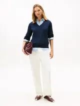 Sweater Tommy Hilfiger de punto trenzado color azul marino, de manga larga con cuello en V y detalles acanalados en puños y dobladillo. Presenta el logo de la marca bordado en el pecho.