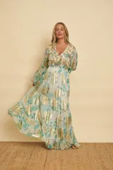 Vestido largo con estampado floral en tonos verde agua y detalles metalizados dorados, con escote en V, mangas largas abullonadas y falda de diseño escalonado.