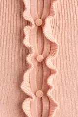 Saco de punto acanalado fino de mezcla de viscosa, color rosado, con ajuste entallado, cuello redondo y cierre frontal de botones. Presenta delicados ribetes con volados en el escote, la tapeta y el bajo.